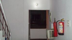 Un pasillo con un extintor colgado en la pared y una puerta al final.