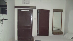 Un dormitorio con una cama de madera, un espejo y una puerta cerrada.