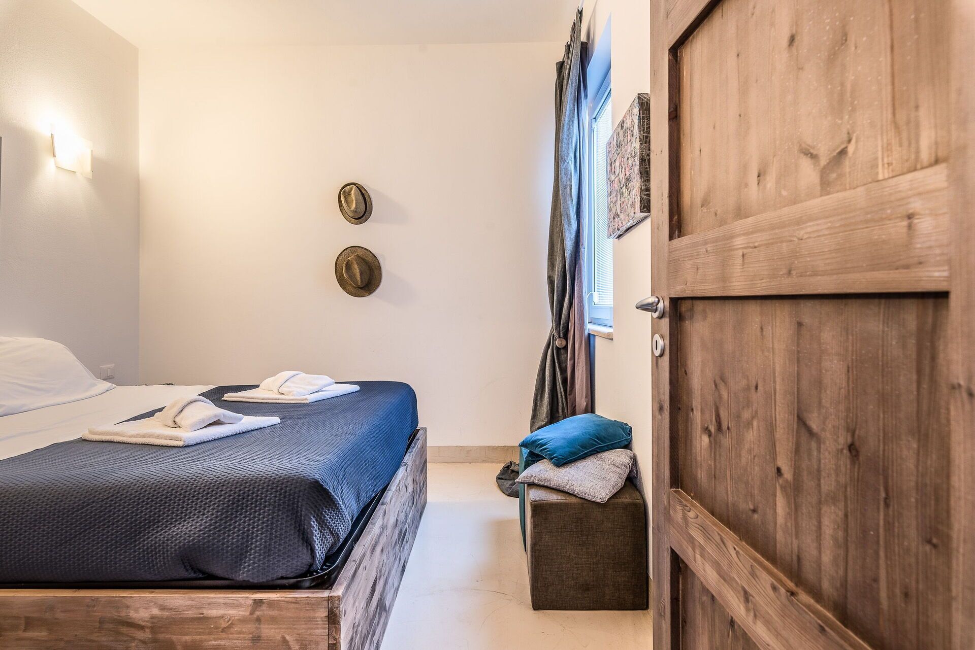 Una camera da letto con un letto, una panca in legno e un armadio.