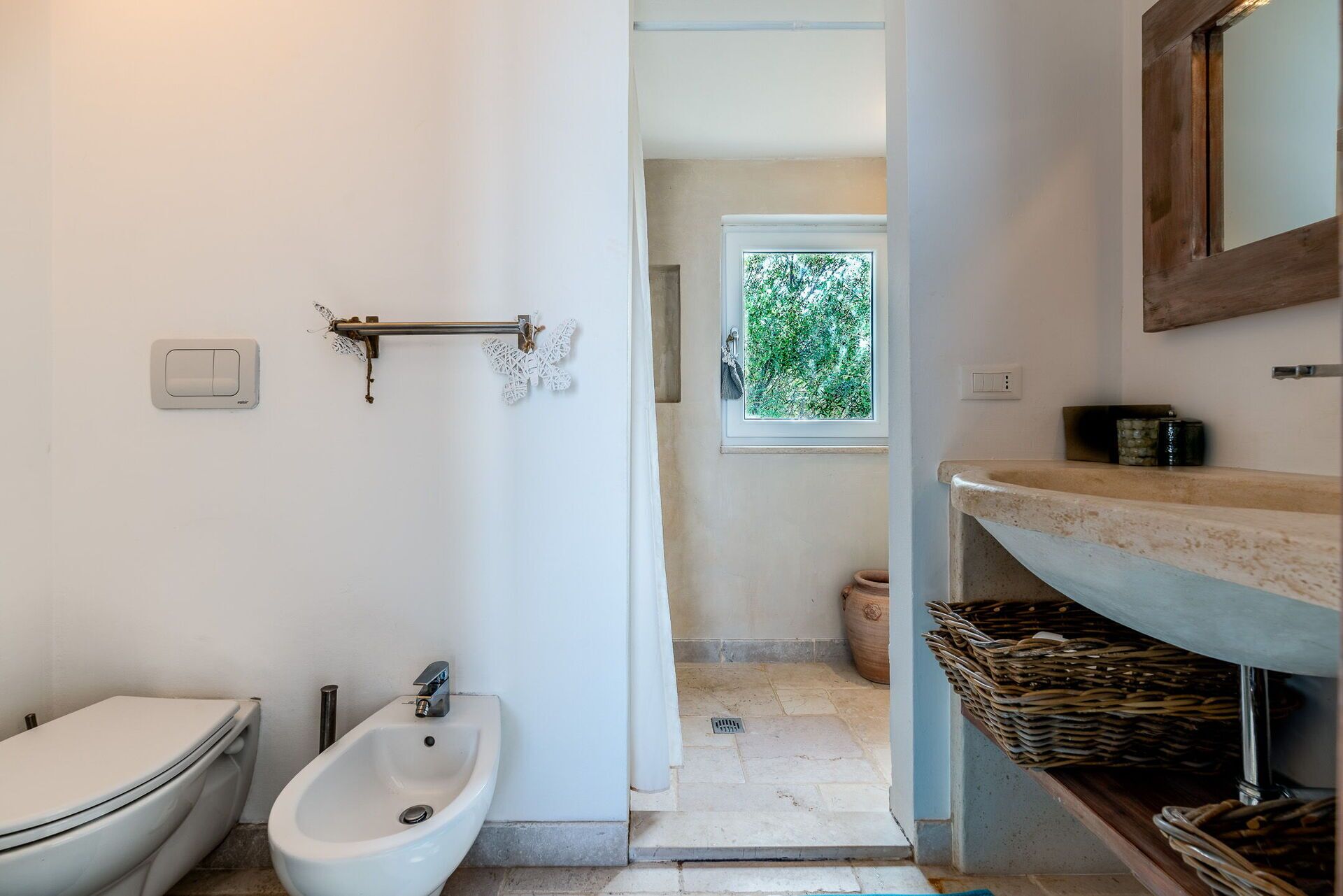 Une salle de bain équipée de toilettes, d’un bidet et d’un lavabo.