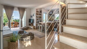 Ein moderner Wohnraum mit Treppe, Essbereich und Küche.