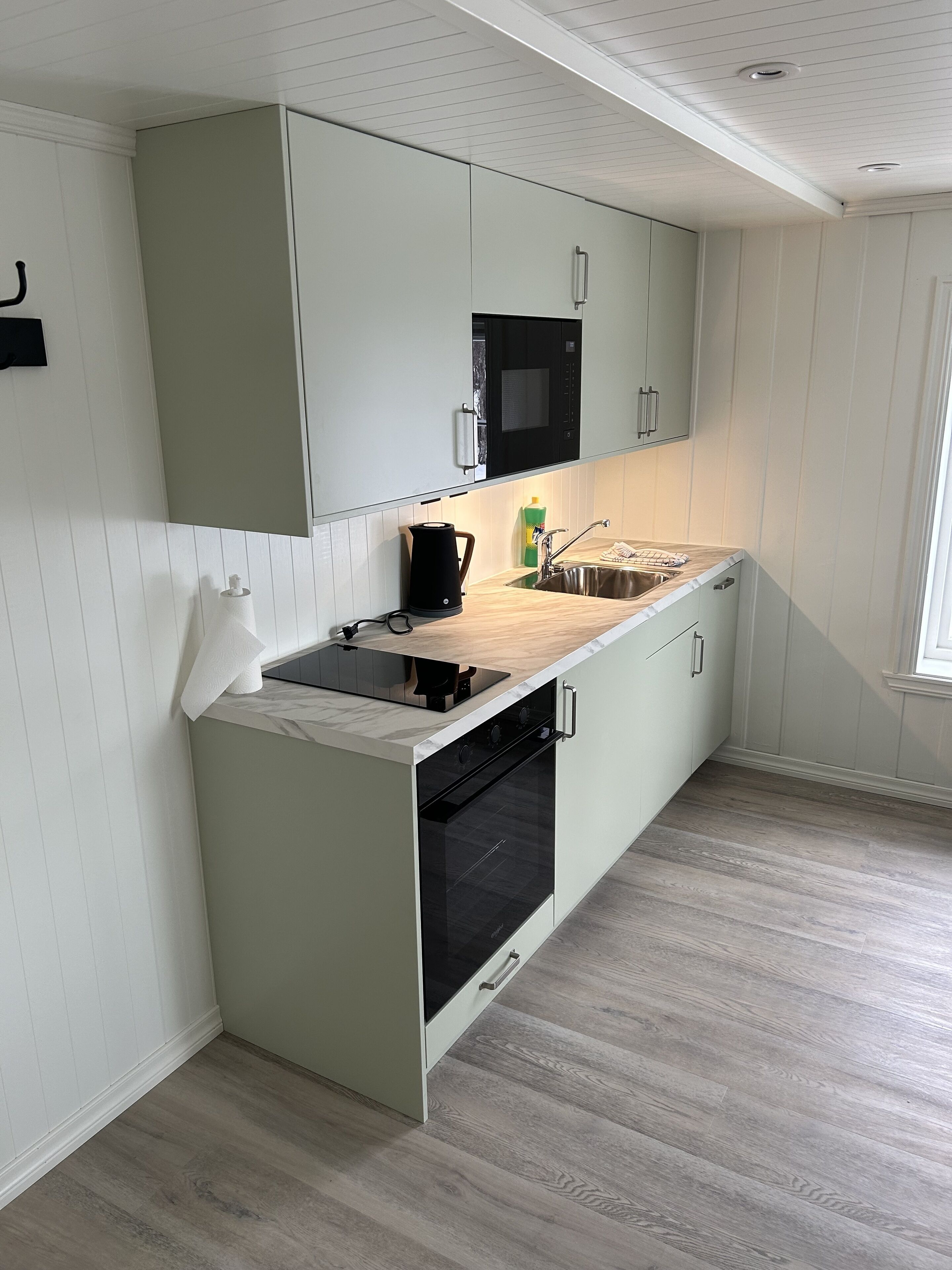 A modern kitchen with a built-in oven, a microwave, and a sink.