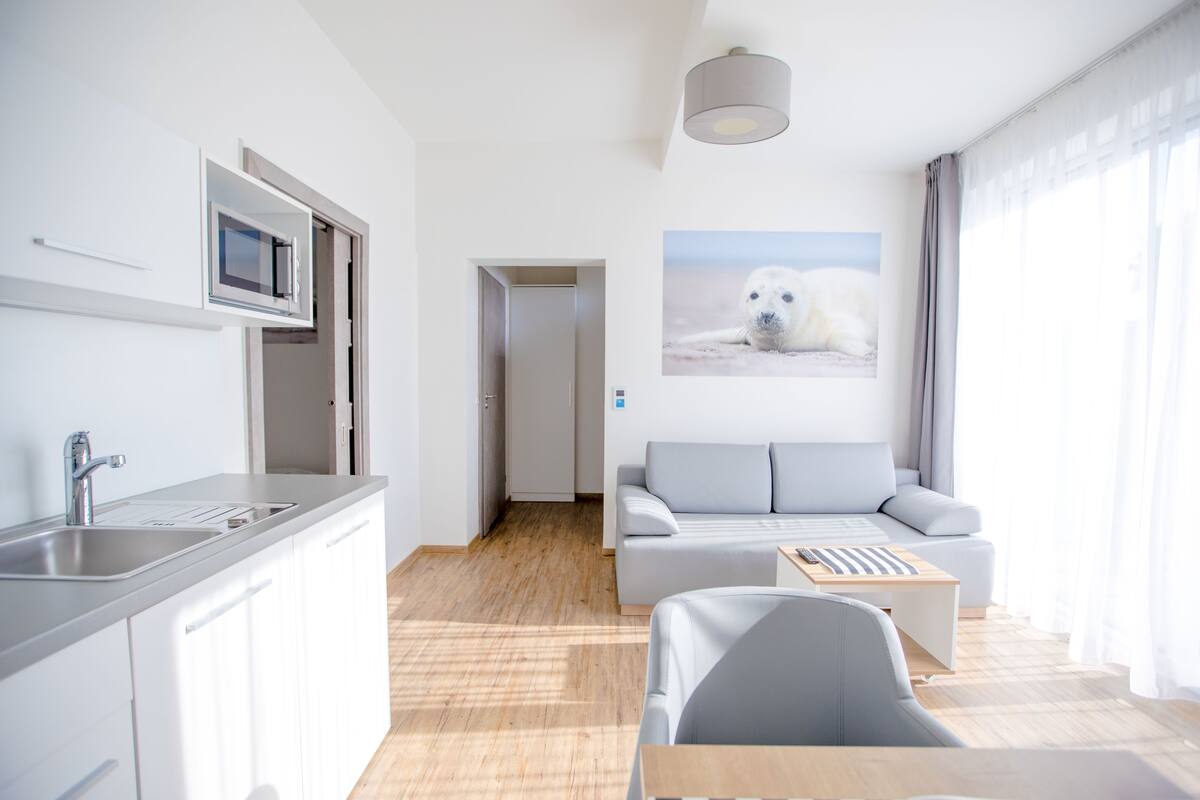 A modern living room with a grey sofa, a wooden coffee table, and a mounted polar bear picture.