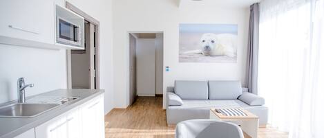 A modern living room with a grey sofa, a wooden coffee table, and a mounted polar bear picture.