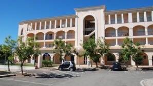 A multi-story hotel with a central courtyard, parking lot, and a clear blue sky. - Vilamoura dream vacation with fantastic beaches, golf courses and marina (Quarteira)