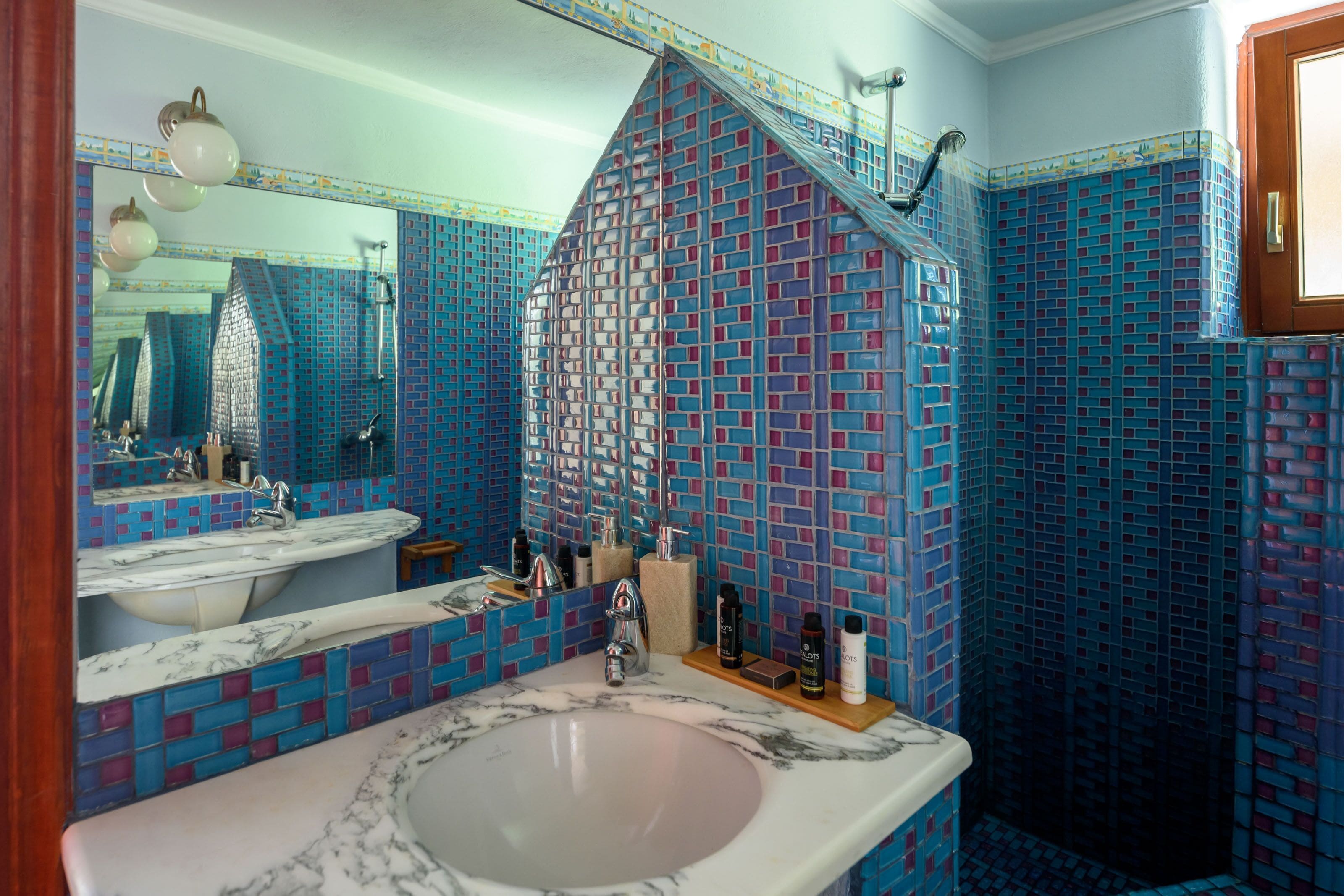 Un baño con un espejo grande, dos lavamanos y una zona de ducha.