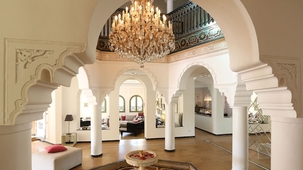 Un hall d’entrée spacieux, doté de hauts plafonds, de lustres somptueux et d’une fontaine centrale.