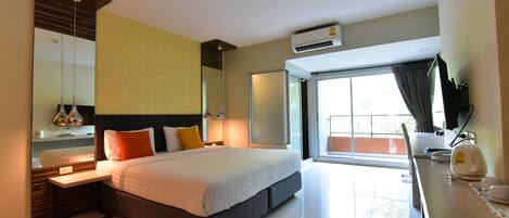 A modern hotel room with a large bed, a bedside table, a mirror, and a window with curtains.