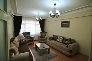 Superior suite | Woonkamer | Een 40-inch flatscreentelevisie met satellietzenders en een ledtelevisie