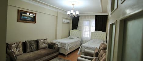 Un dormitorio con dos camas, un sofá y una silla.