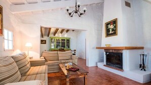 A spacious living room with a fireplace, a sofa set, and a dining table. - Nice typical Menorcan house, with good location (es mercadal)
