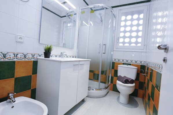 A bathroom with a shower enclosure, toilet, sink, and a potted plant. - QUEENS 2B Salou center, beach at 300m (Salou)