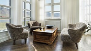 A room with large windows, a wooden coffee table, and three armchairs. - Hótel Búðir (Snæfellsbær)