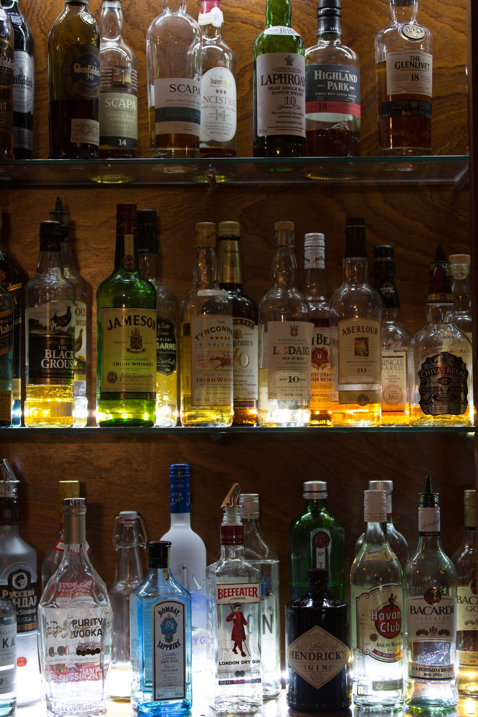 Variedad de botellas de licor exhibidas en estantes.