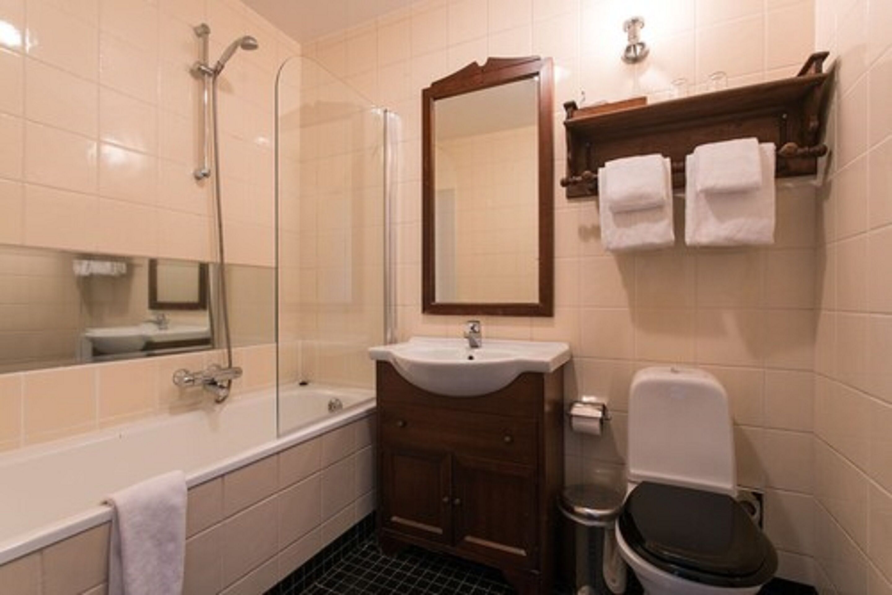 A bathroom with a bathtub, a sink, a toilet, and a mirror.