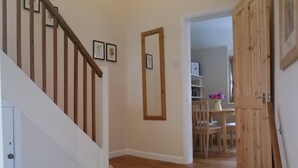 A wooden staircase leading to a room with a white door, a wooden floor, and a wall with framed pictures. - Charming English cottage, Ashdown Forest, excellent pub (Danehill)
