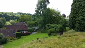 A house with a sloped roof, a visible chimney, and a well-maintained lawn. - Charming English cottage, Ashdown Forest, excellent pub (Danehill)