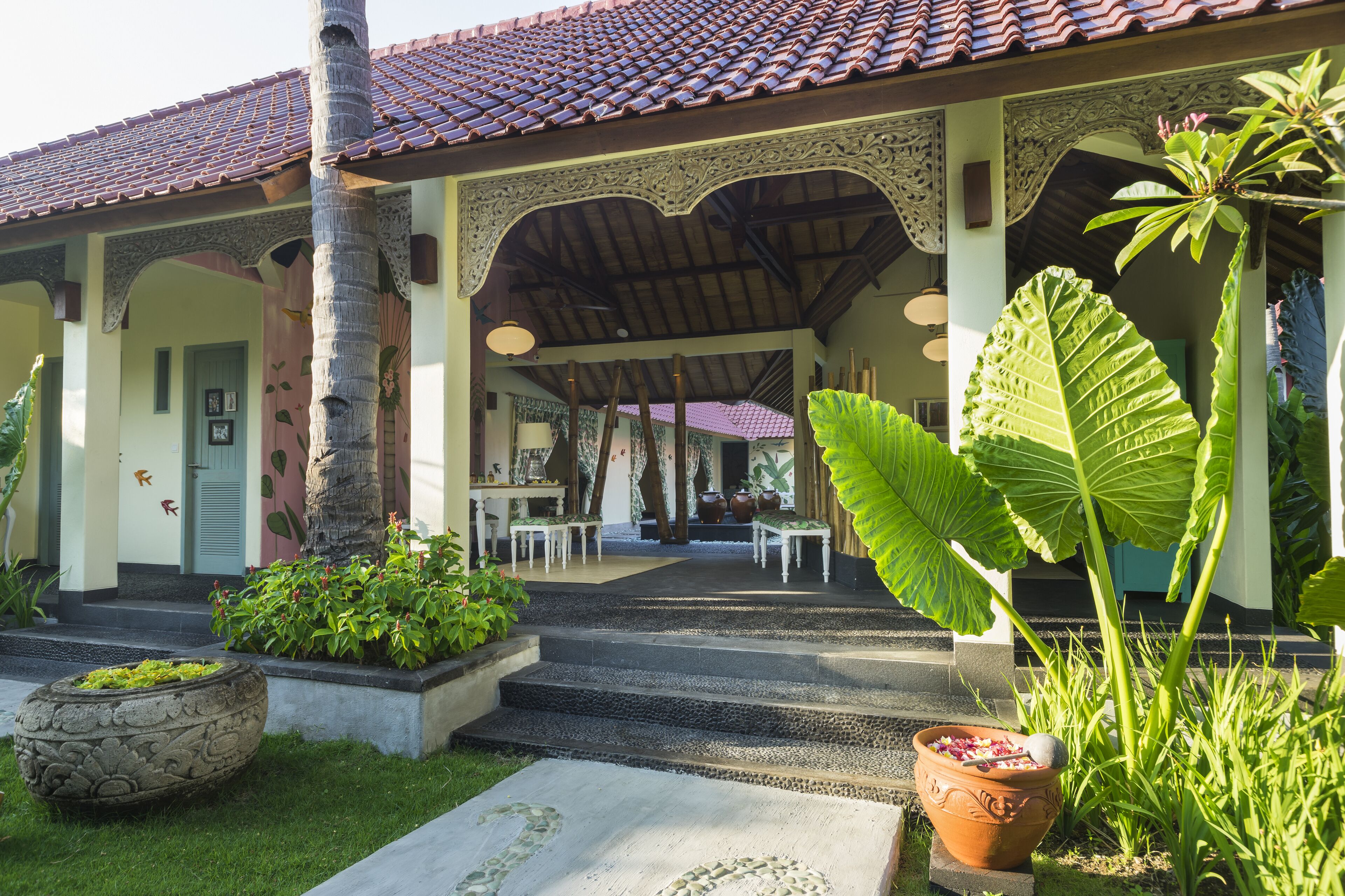 A traditional building with a tiled roof, a covered porch, and a stone pathway leading to the entrance.