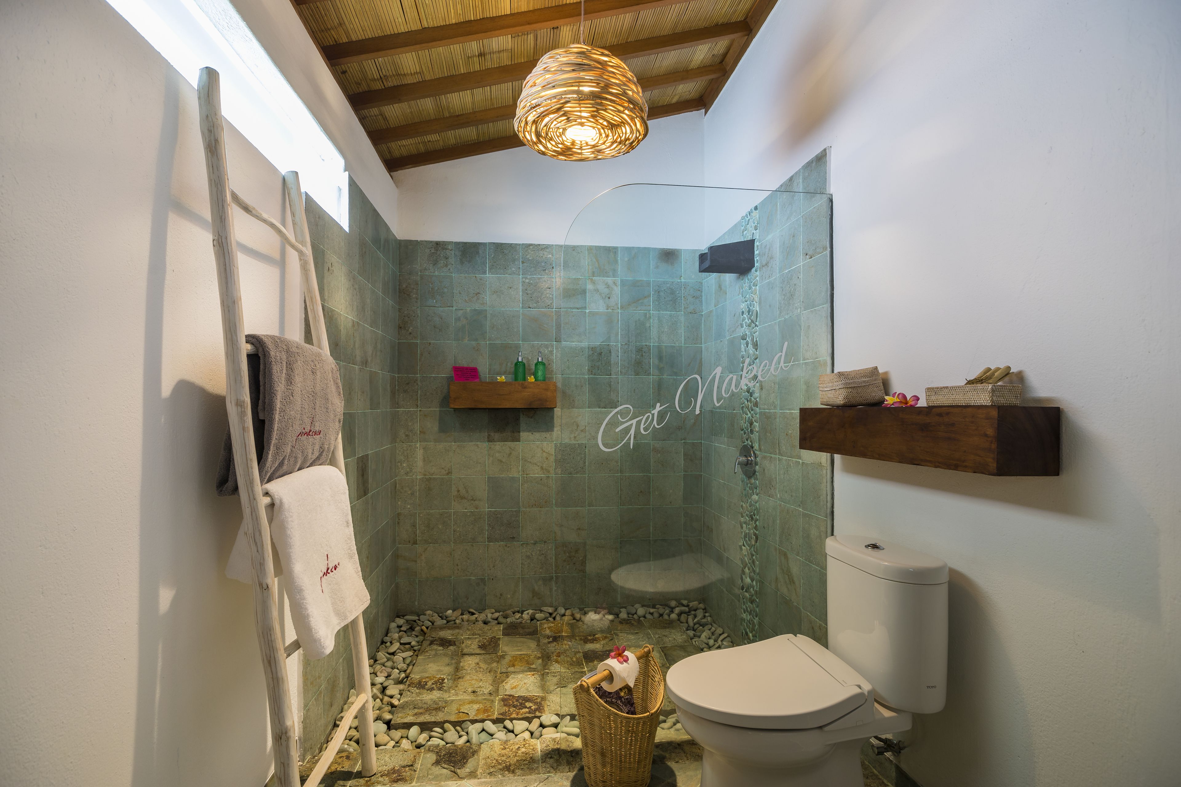 A bathroom with a shower, toilet, and a towel rack.