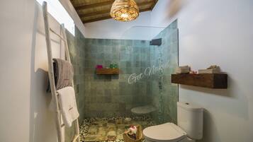 Une salle de bain avec une douche, des toilettes et un porte-serviettes.
