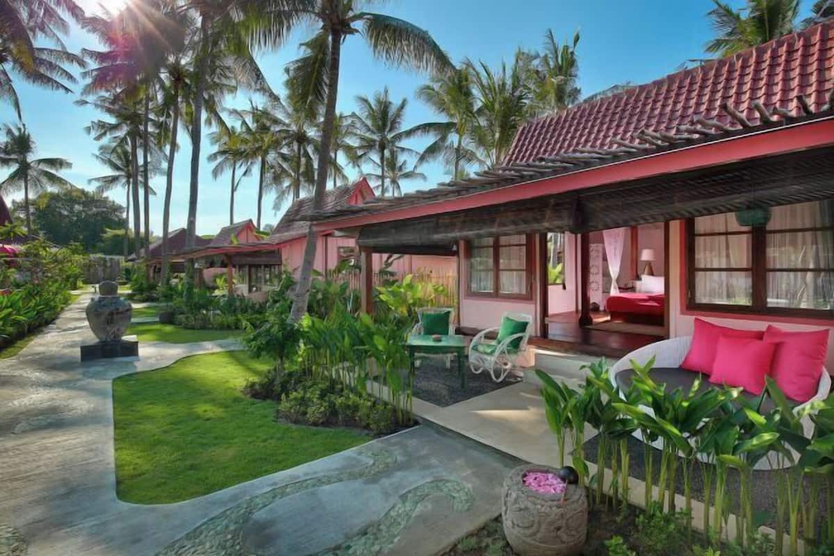 A resort with multiple villas, each featuring a private garden, outdoor seating, and a pool area.