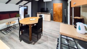 A compact living space with a dining area, kitchenette, and a sofa with cushions. - Pet friendly apartment in Njivice with WiFi (Njivice)