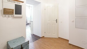 A hallway with a white door, a wooden chest, and a wall-mounted storage unit labeled "ORGANISER".
