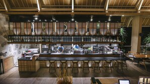 A modern bar area with a long counter, stools, and a high ceiling with wooden beams. - Marc Hotel Gili Trawangan (Gili Trawangan)