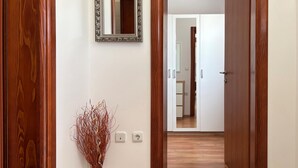 A hallway with wooden doors, a white vase with branches, a mirror, and a white cabinet. - 1 bedroom nice home in Zminj (Zminj)