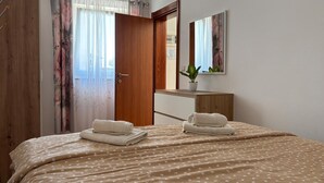 A bedroom with a bed, two towels, a wooden dresser, a potted plant, and a mirror. - 1 bedroom nice home in Zminj (Zminj)