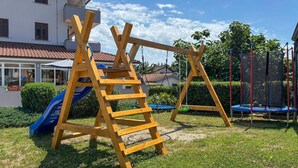 A wooden swing set and slide in a grassy yard with a house in the background. - 1 bedroom nice home in Zminj (Zminj)
