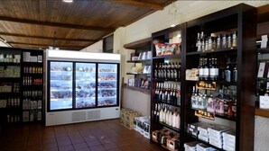 A store with shelves stocked with various products, a refrigerated display case, and a tiled floor. - Hotel Ciudad de Plasencia (Plasencia)