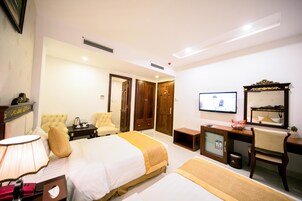 A hotel room with a bed, a desk, a chair, a television, and a mirror.