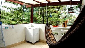 Un baño pequeño con un lavabo blanco, un armario blanco y una silla hamaca.