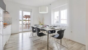 Una cucina moderna con zona pranzo, vista esterna e un'ampia finestra.