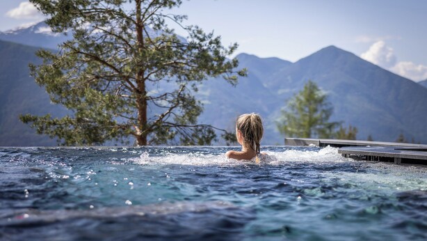 Une personne dans un bain à remous avec vue sur la montagne.