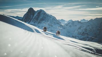 Un paisaje montañoso nevado con dos teleféricos.