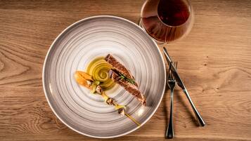 A plate with a grilled steak, mushrooms, and a skewer of vegetables on a wooden table.