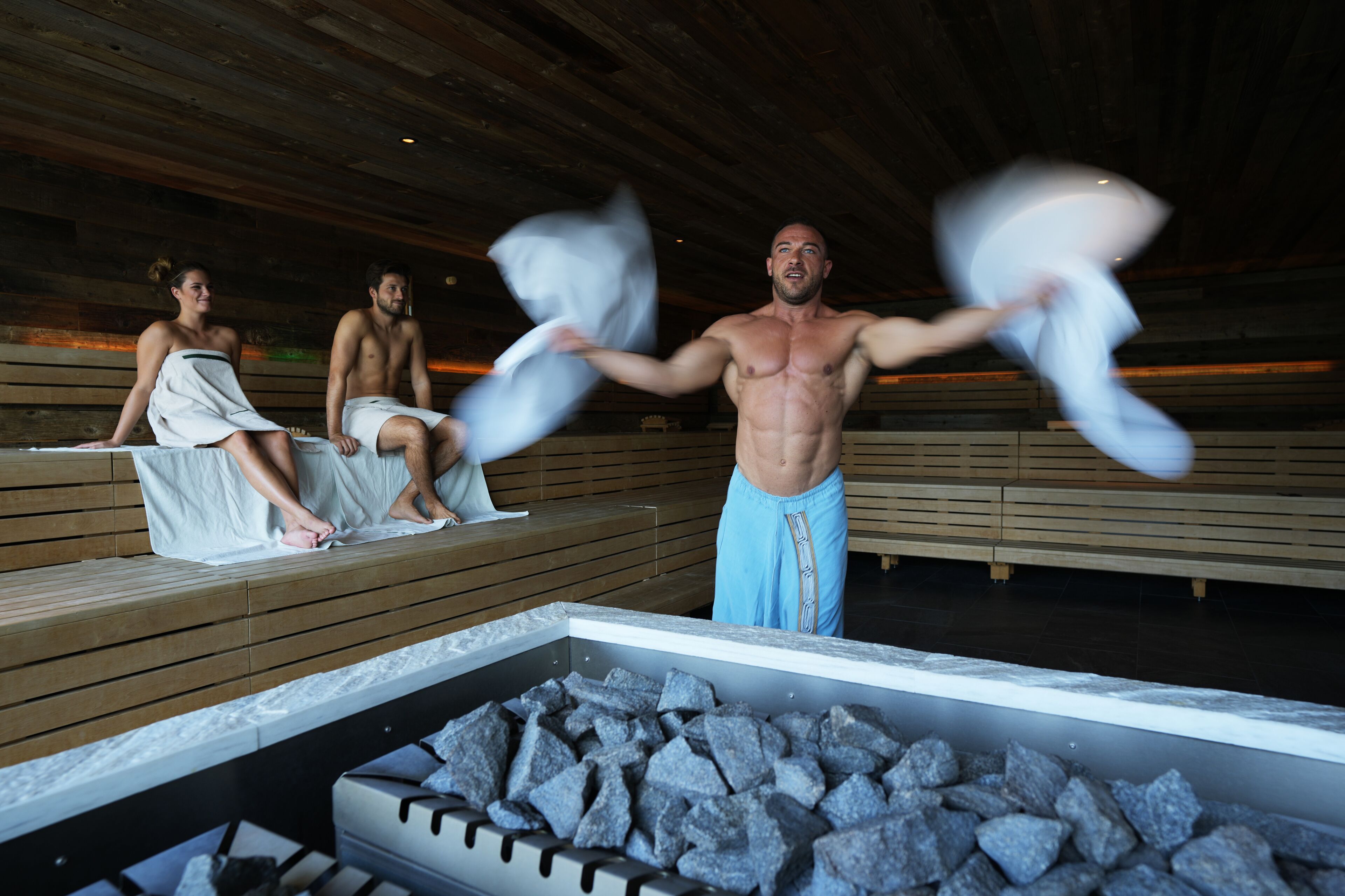 Eine Sauna mit Holzbänken und einem Steingefäß.