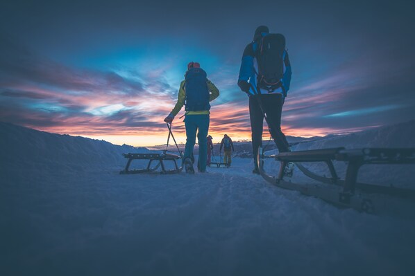 Paisaje nevado con trineos y personas.