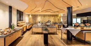 Una cocina moderna con armarios de madera, una isla central y diversos alimentos exhibidos en la encimera.