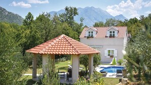 A house with a red-tiled roof, a pool, and a garden with a gazebo. - Beautiful home in Slime (Slime)