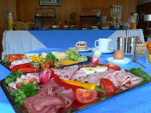A breakfast buffet with various meats, cheeses, fruits, and a muffin. - Hotel Meran Hallenbad & Sauna (Saarbrücken)