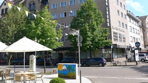 Un hôtel à plusieurs étages, doté d’un espace extérieur aménagé et offrant une vue sur la rue.