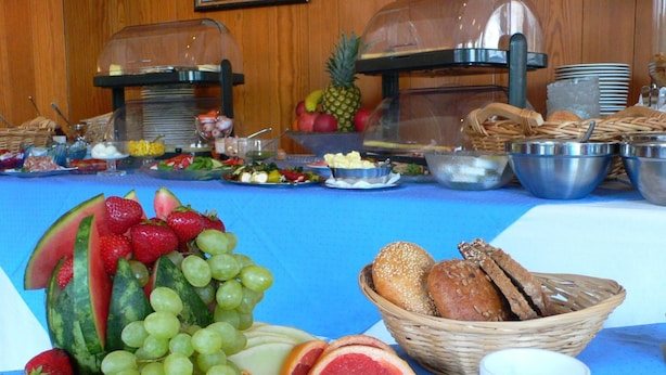 Un buffet de petit-déjeuner proposant une variété de fruits, de pains et de boissons.