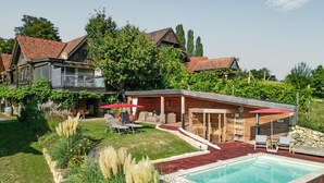 A residential property with a swimming pool, outdoor seating area, and a covered patio. - Ferienhaus mit Pool und Sauna (Breitenfeld)