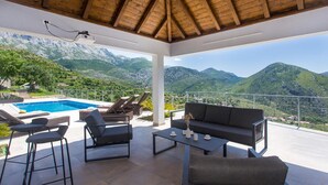 A covered outdoor seating area with a pool, lounge chairs, and a sofa. - Nice home in Zrnovnica (Zrnovnica)