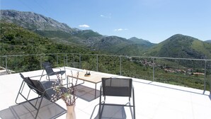 A terrace with two chairs and a table, overlooking a mountainous landscape. - Nice home in Zrnovnica (Zrnovnica)