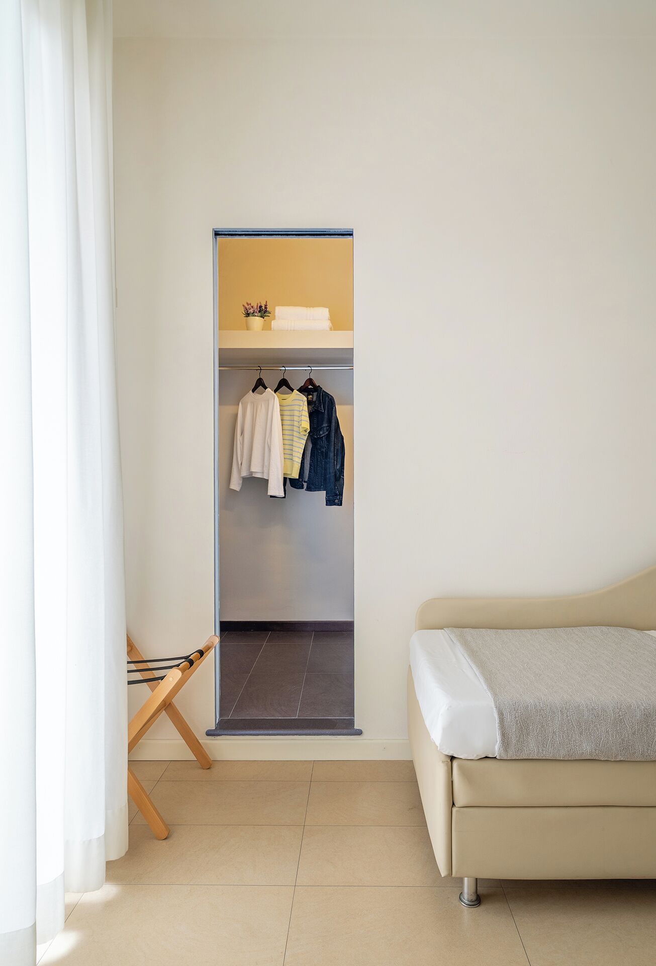 Quarto com cama, armário e um varal.