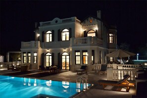 Una piscina al aire libre, una piscina climatizada, sombrillas